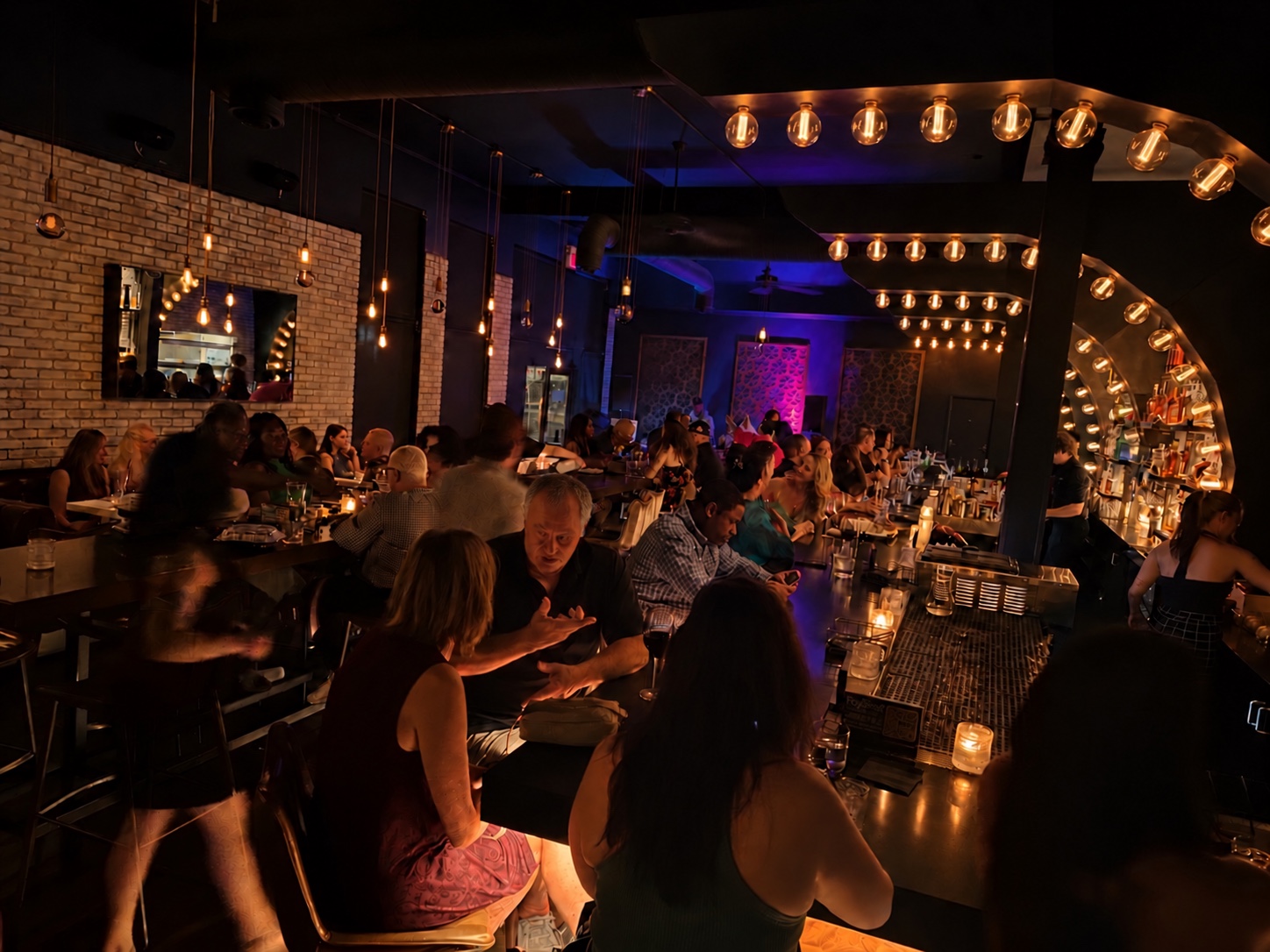 Guests gathered at the BlackSheep bar and dining tables beneath warm glowing arches